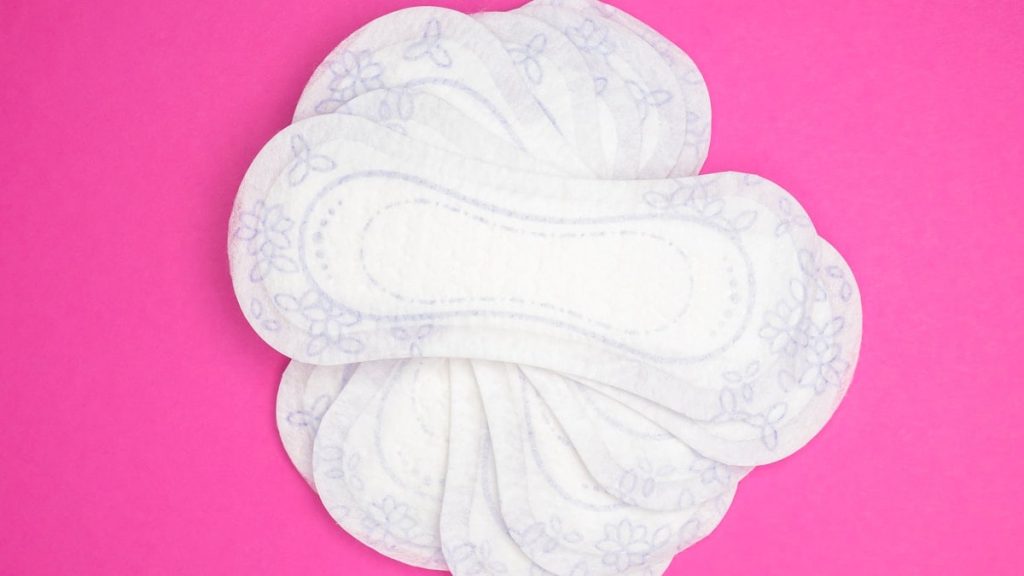Menstrual products and supplies (pads, tampons, menstrual cups) on a colorful background.